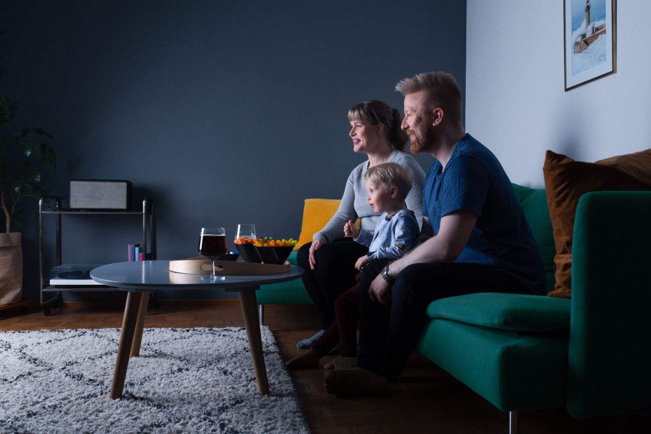 Perhe katsoo televisiota sohvalla